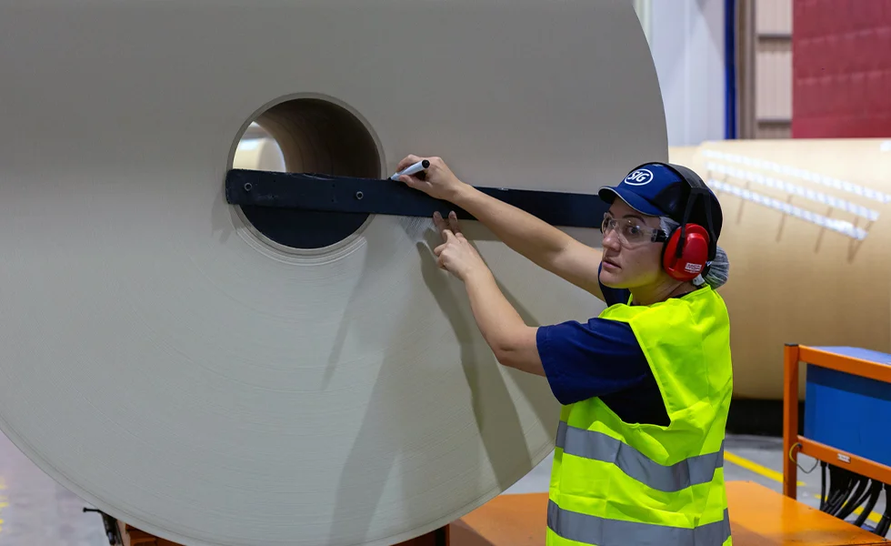 The image features a woman working in a factory setting