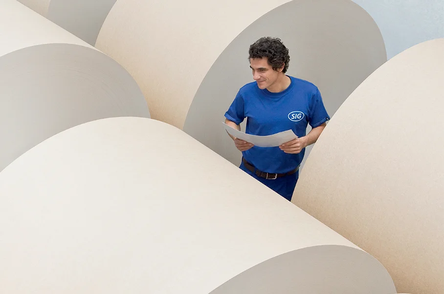 In this image, there is a man standing in front of a large rolls.