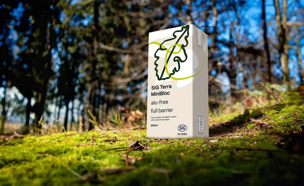 The image features a SIG packaging unit set on the ground in a forest setting. 