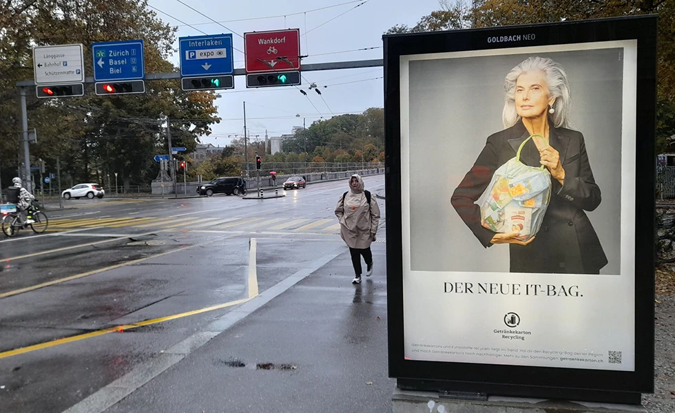 Street scene with a recycling poster at a rainy intersection. (photo)