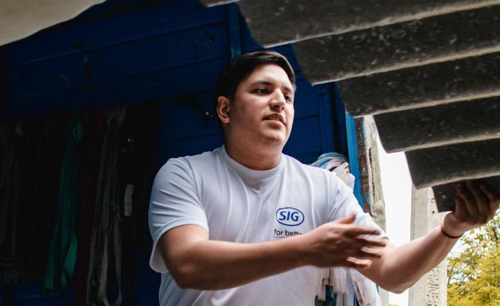 A man unloading stacked panels from a truck (photo)
